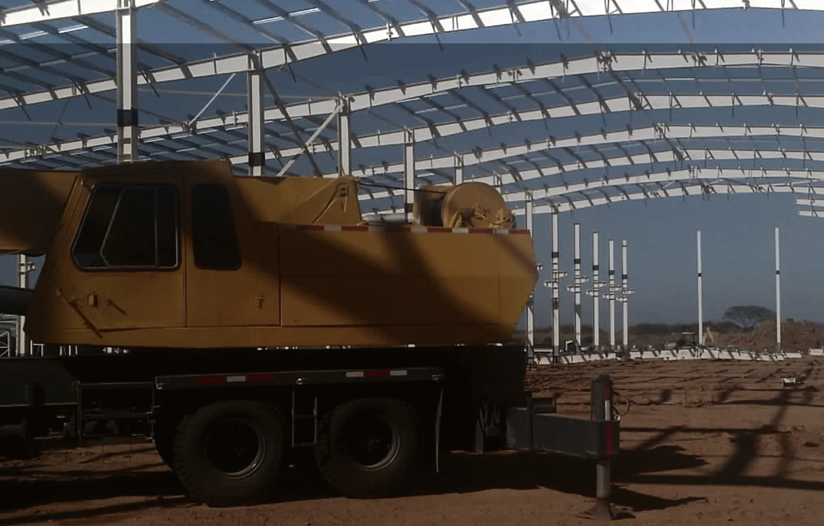 Curved steel structure being erected under a crane on an ONIX job